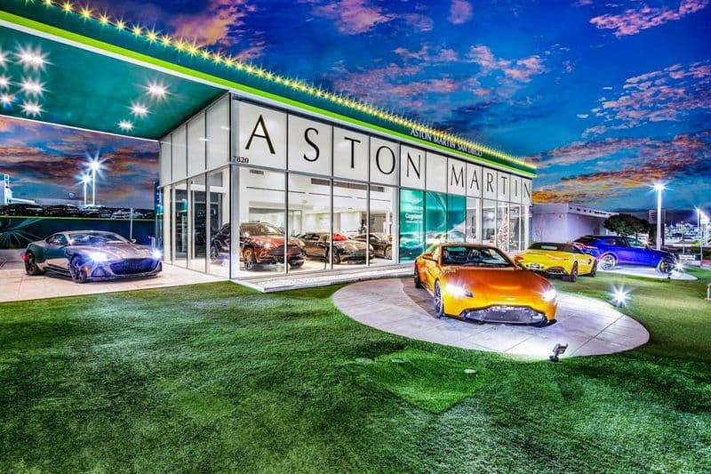 Aston Martin dealership showroom and display vehicles illuminated after dark