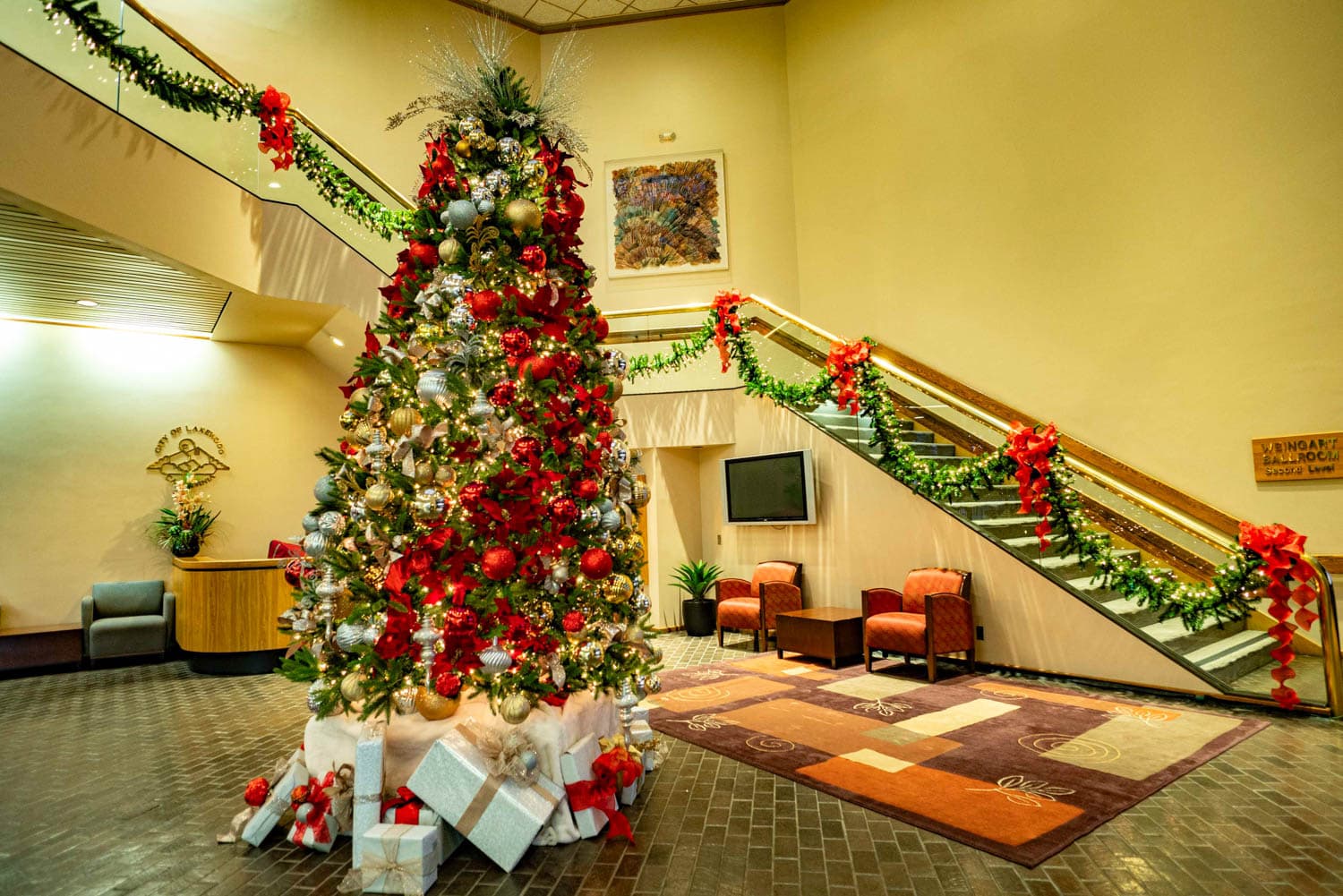 Large professionally decorated Christmas tree and garland in a public institutional lobby