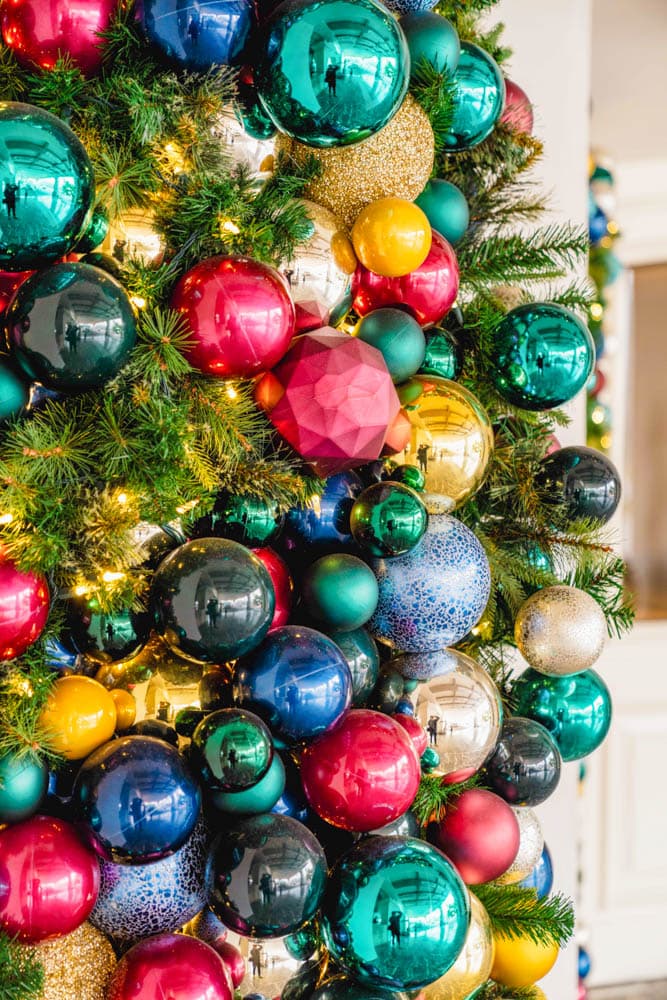 Close view of jewel-toned ornaments and greenery in a commercial holiday installation