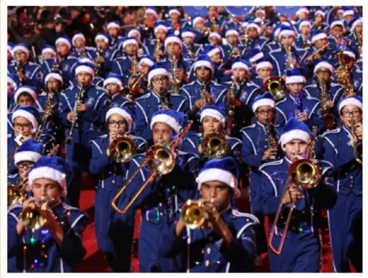 A marching band in Santa hats performing in the Hollywood Christmas Parade