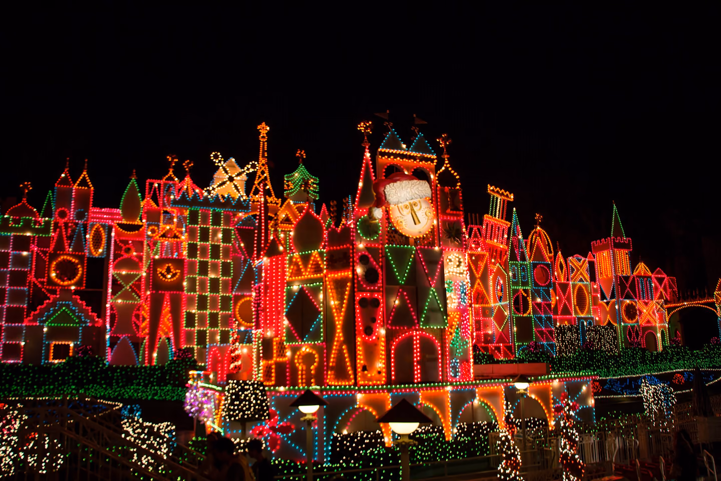 The It's a Small World facade covered in colorful holiday lights at Disneyland