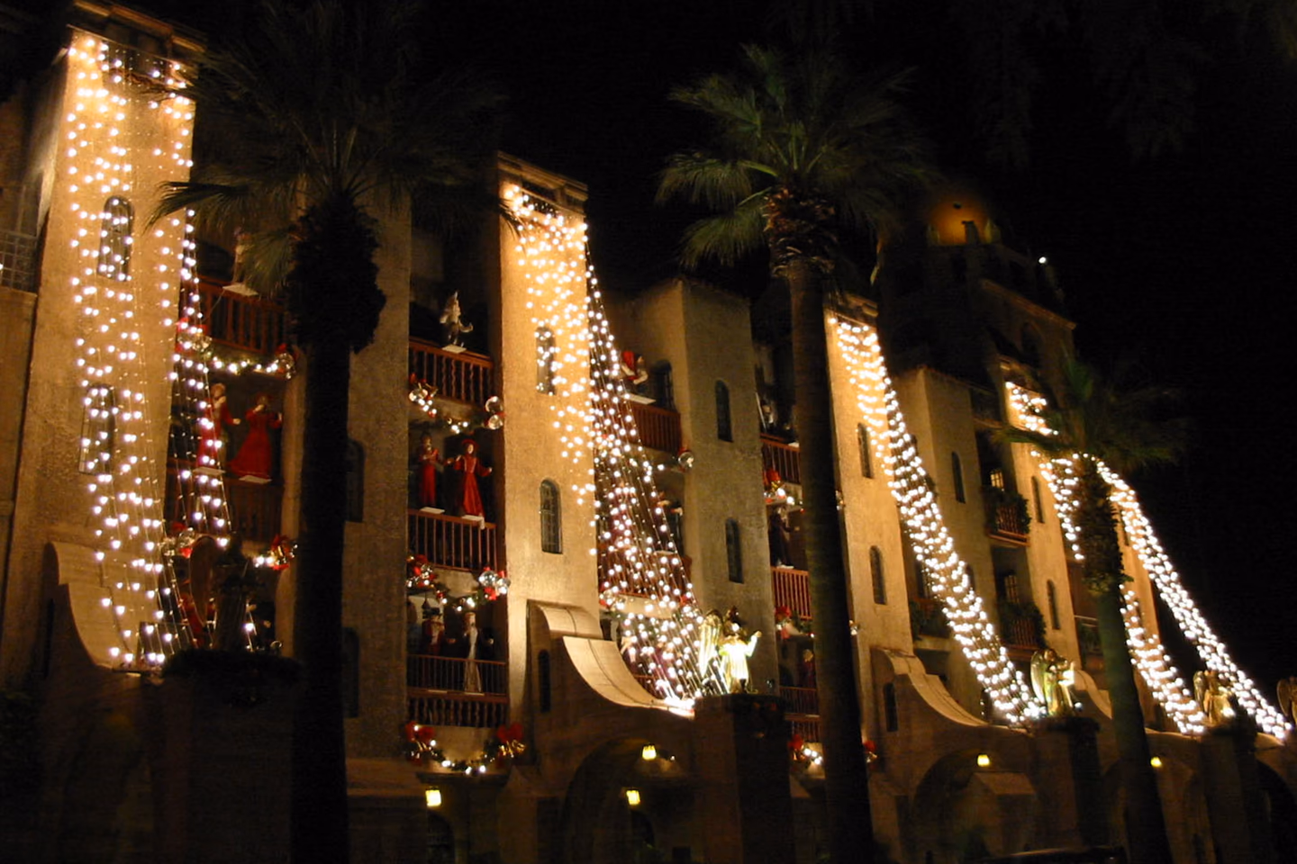 The Mission Inn illuminated with multicolored holiday lights at night