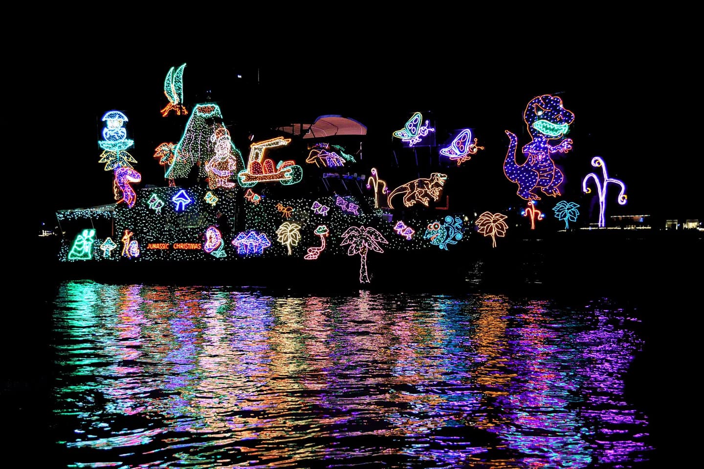 A brightly decorated boat reflected in Newport Harbor during the Christmas Boat Parade